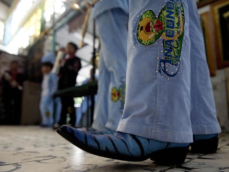 Ein Besucher eines Narcocorridos-Konzerts in Jeans und auffälligen Cowboy-Stiefeln. 