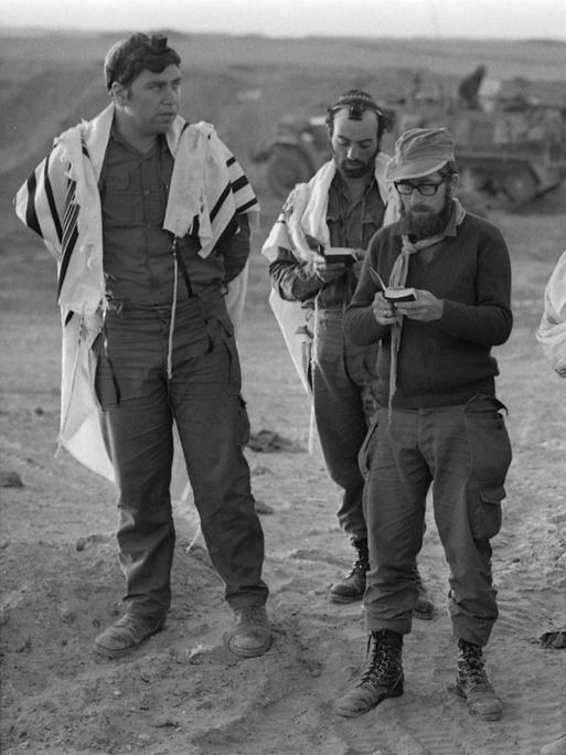 Israelische Soldaten stehen zusammen und beten während des Jom Kippur-Kriegs 1973. 