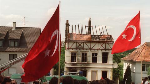 Demonstranten tragen am 29. Mai 1993 vor dem ausgebrannten Haus der Familie Genç in Solingen türkische Fahnen. 