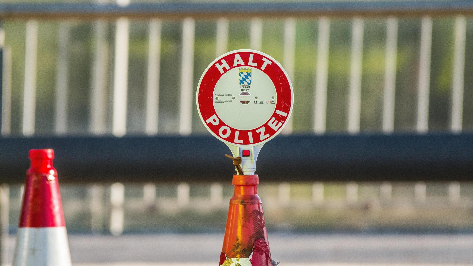Eine Polizeikelle mit der Aufschrift "Halt Polizei" ist in ein Verkehrskegel gesteckt. Im Hintergrund ist ein weiterer Verkehrskegel. Eine Polizeikelle mit der Aufschrift "Halt Polizei" ist in ein Verkehrskegel gesteckt. Im Hintergrund ist ein weiterer Verkehrskegel.