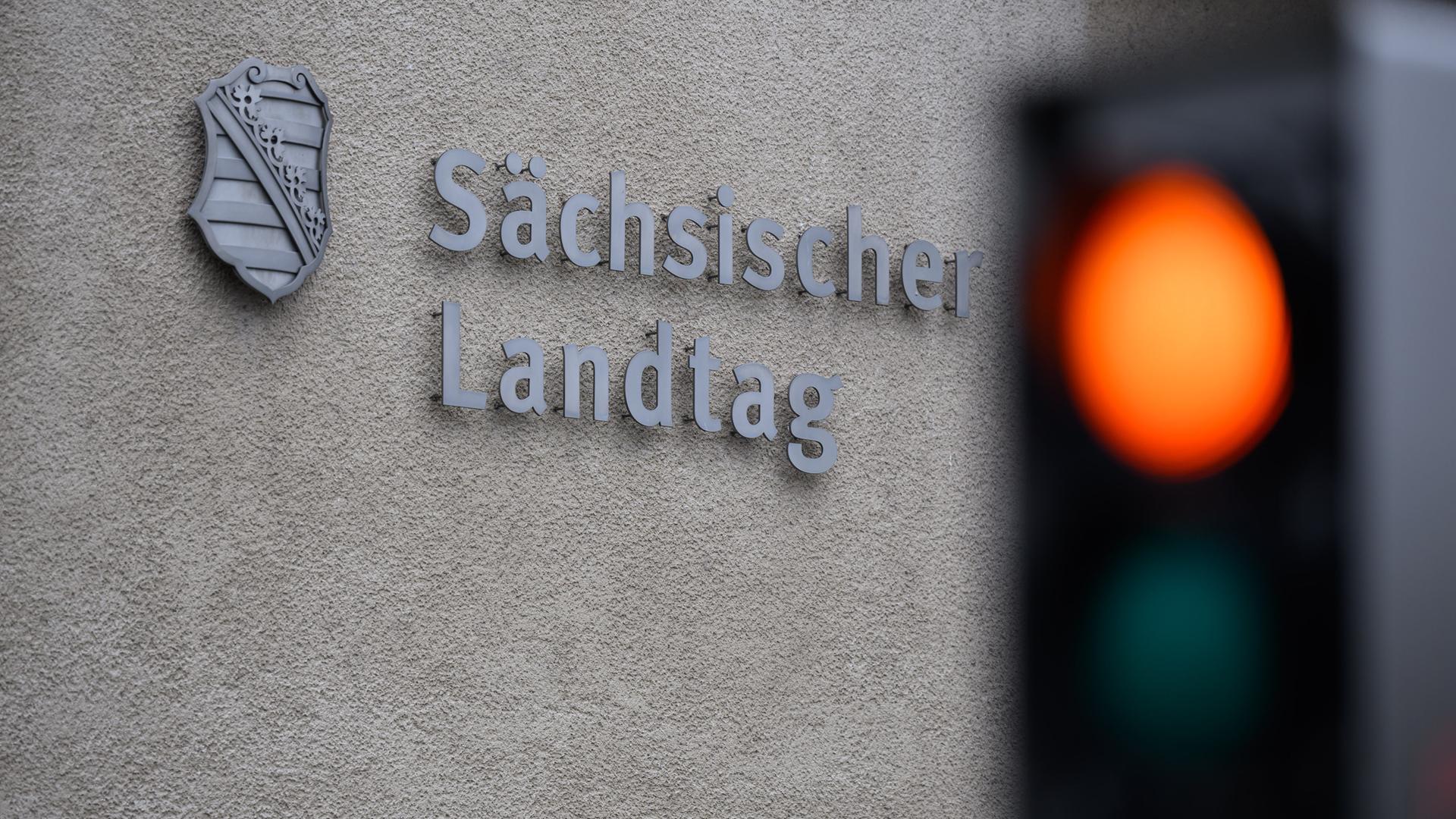 Ein rote Ampel leichtet am Eingang vor dem Sächsischen Landtag.