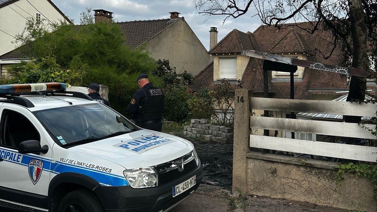 Ein Polizeiauto vor dem Haus des Bürgermeisters von L'Haÿ-les-Roses. Der Zaun ist angekokelt.