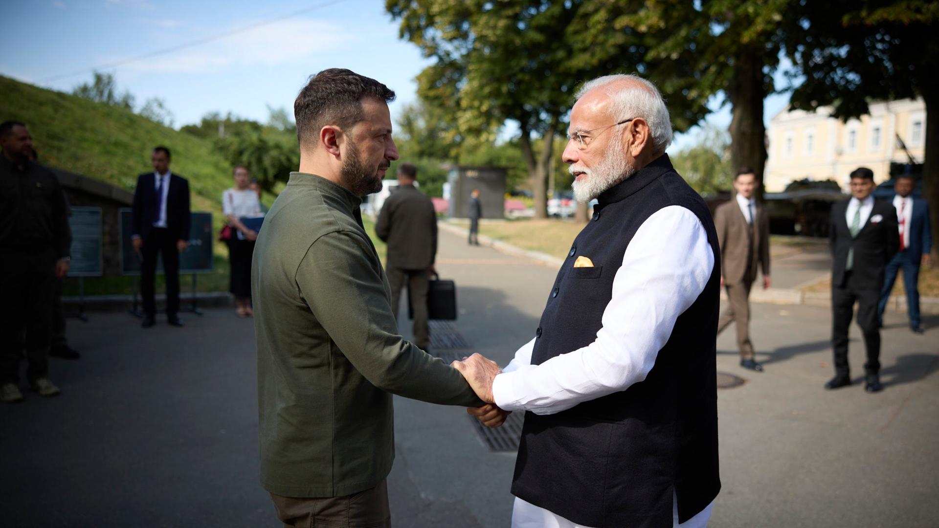 Indiens Premierminister Modi und der ukrainische Präsident Selenskyj drücken sich die Hände. 