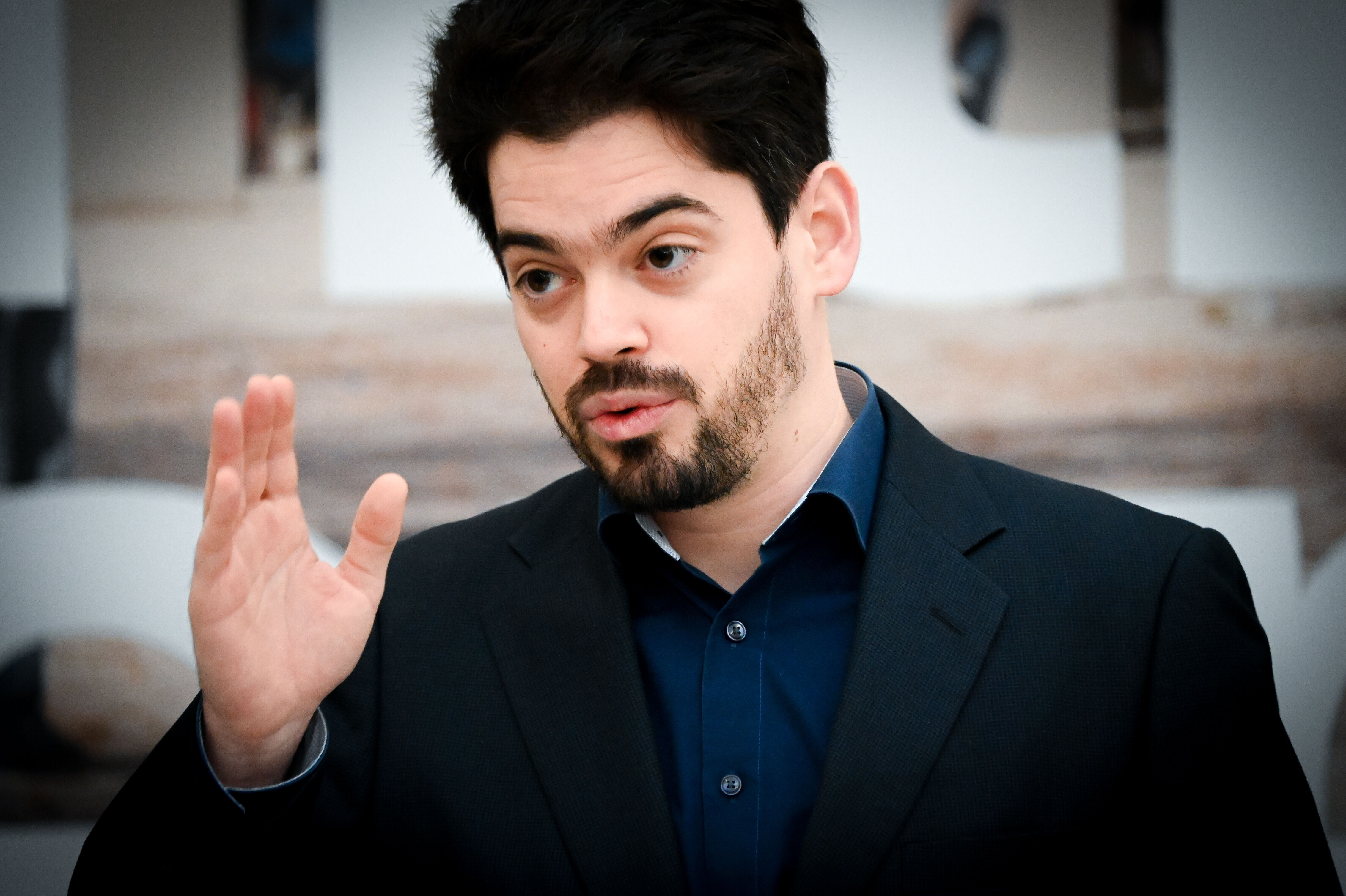 Der Dirigent Lahav Shani erhebt mit ernster Miene seine Hand.