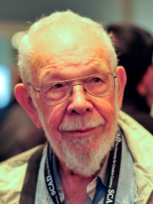 Der US-Cartoonist Al Jaffee im Jahr 2011 mit einer silbernen Brille, weißem Bart und einer beigen Jacke.