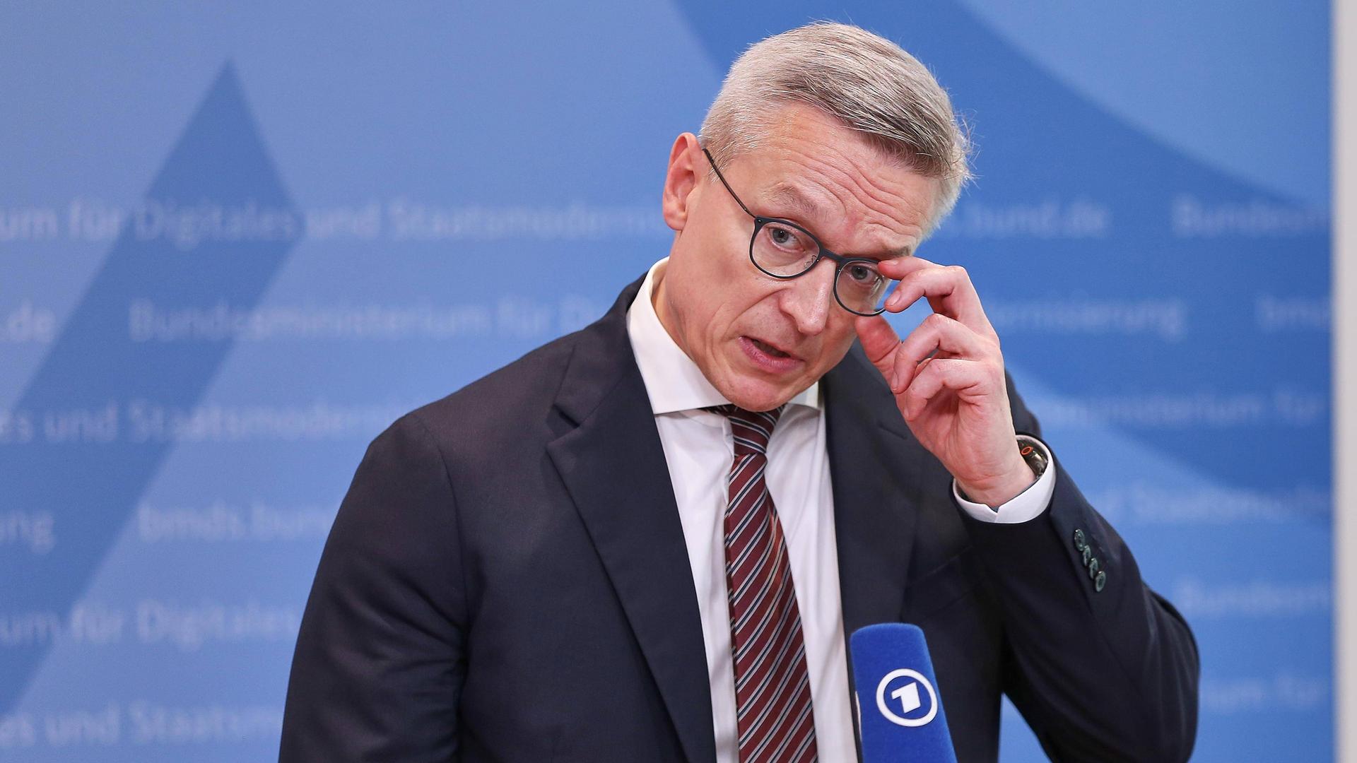 Bundesminister für Digitales und Staatsmodernisierung Karsten Wildberger (CDU) greift sich bei einer Pressekonferenz an die Brille.
