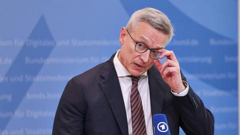 Bundesminister für Digitales und Staatsmodernisierung Karsten Wildberger (CDU) greift sich bei einer Pressekonferenz an die Brille. Bundesminister für Digitales und Staatsmodernisierung Karsten Wildberger (CDU) greift sich bei einer Pressekonferenz an die Brille.