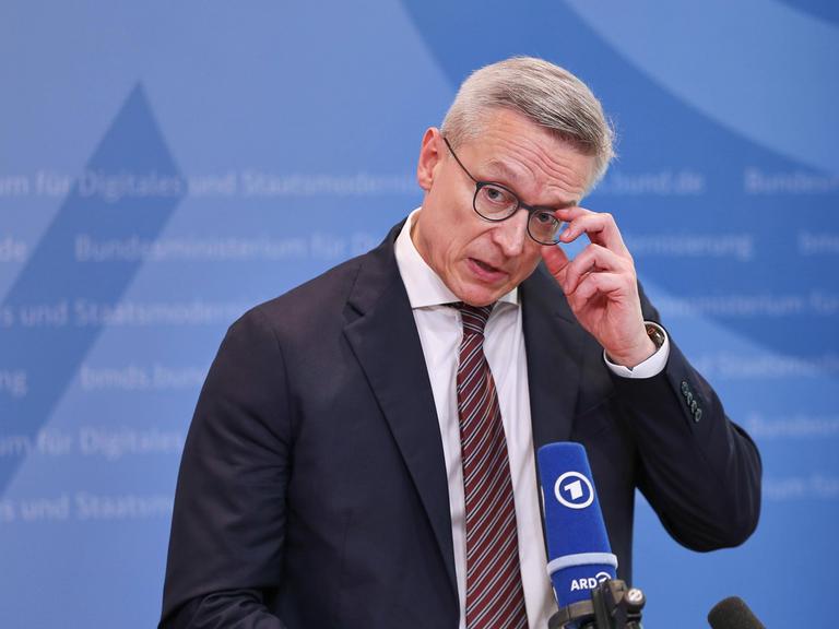 Bundesminister für Digitales und Staatsmodernisierung Karsten Wildberger (CDU) greift sich bei einer Pressekonferenz an die Brille.