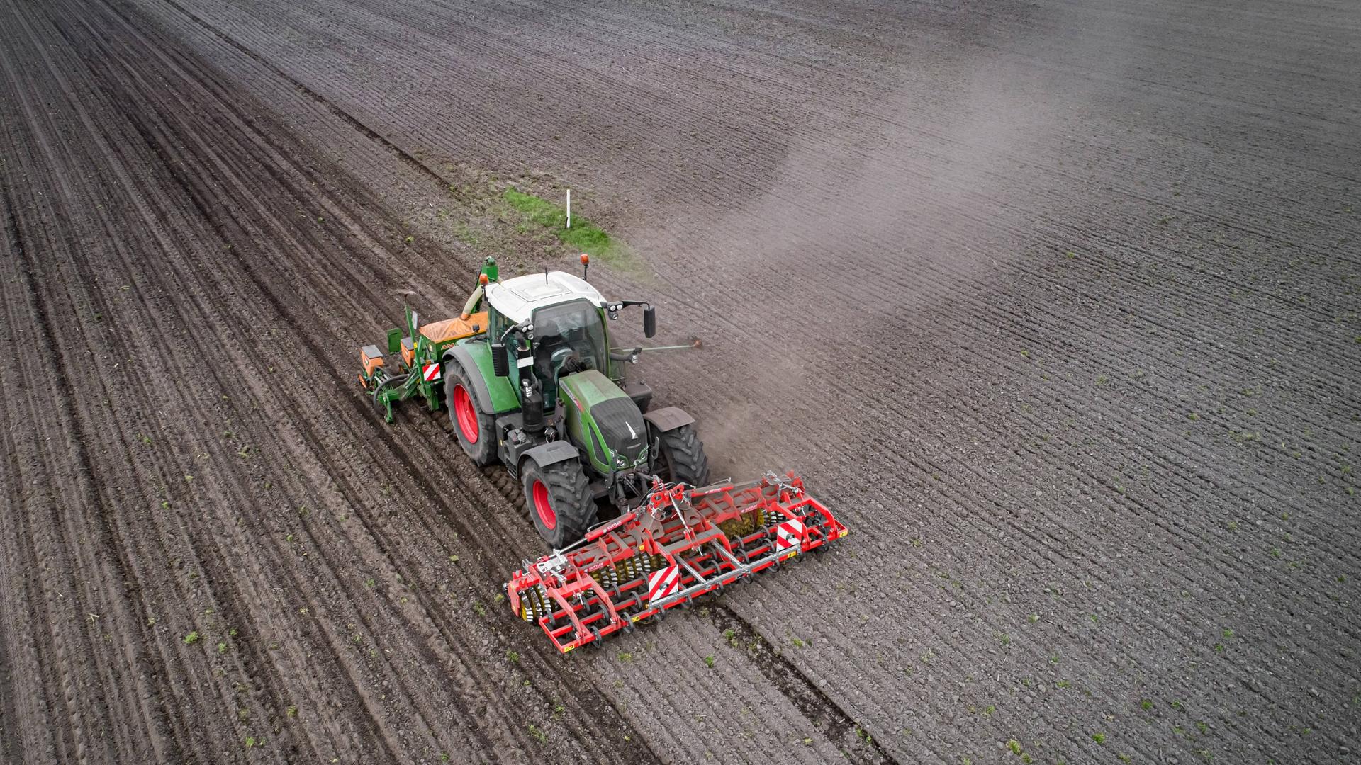 Traktor mit Maislegegerät bei der Aussaat von Mais, Luftaufnahme. 