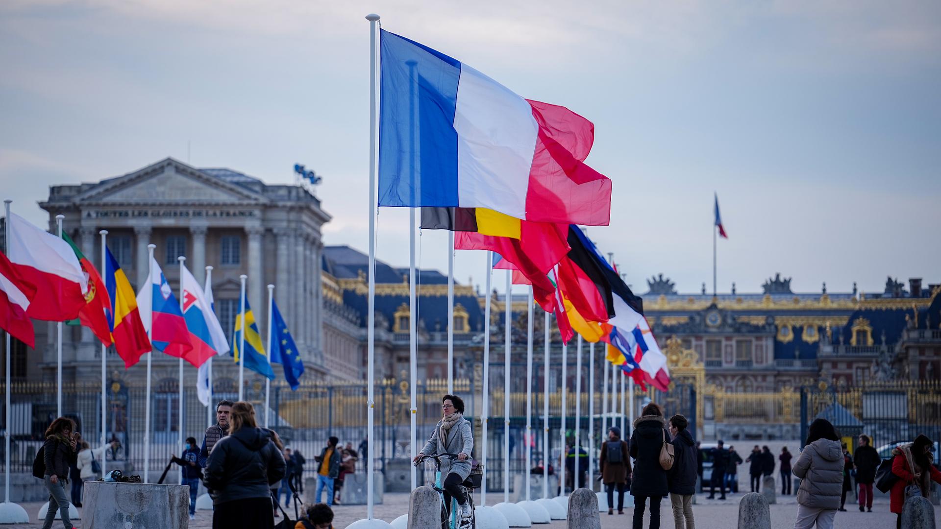 Die Fahnen der EU-Mitgliedsstaaten wehen vor dem Schloss in Versailles im Wind.  