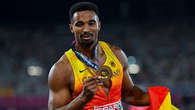 10-Kämpfer Leo Neugebauer hält seine Gold-Medaille in die Kamera.