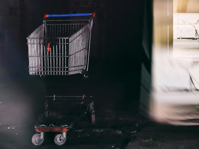 Ein Toter im Drogeriemarkt. War es Mord? Zu sehen: Ein Einkaufswagen steht neben dem Hinterausgang eines Geschäfts. 