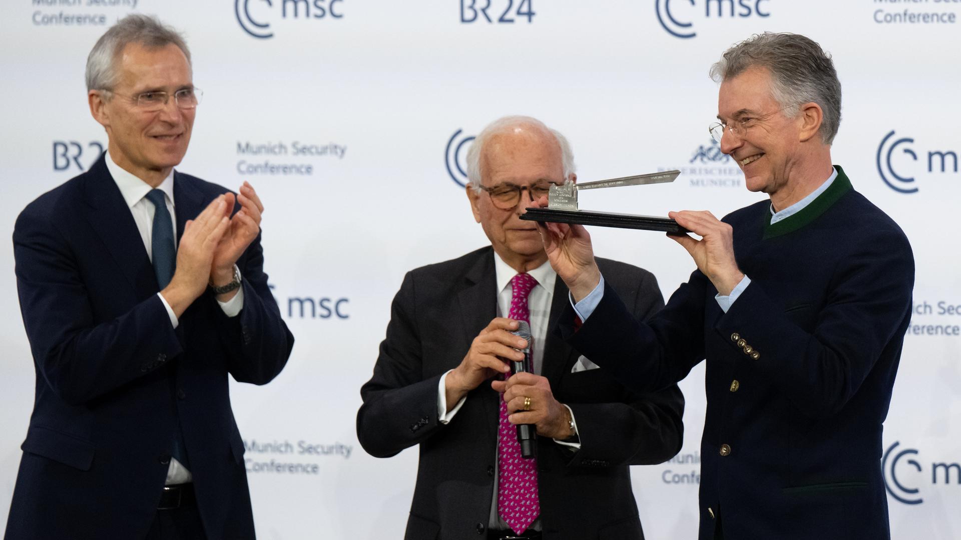 Das Bild zeigt Jens Stoltenberg, Wolfgang Ischinger und Christoph Heusgen auf der Münchner Sicherheitskonferenz. 