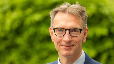 Daniel Fuhrhop trägt eine Brille und lächelt in Richtung des Betrachters.
