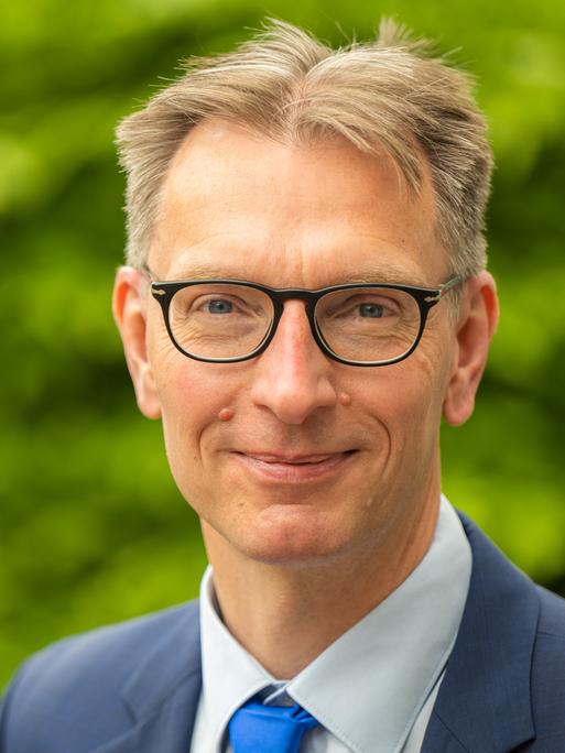 Daniel Fuhrhop trägt eine Brille und lächelt in Richtung des Betrachters. Daniel Fuhrhop trägt eine Brille und lächelt in Richtung des Betrachters.