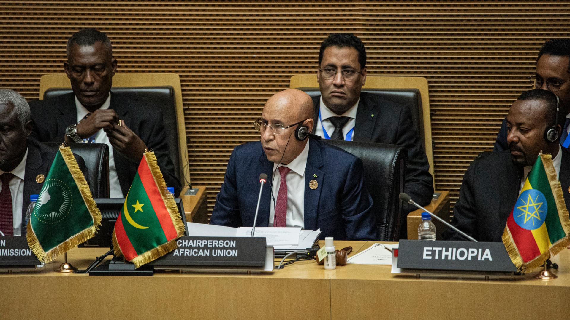Vertreter der Afrikanischen Union sitzen auf Sesseln in einem Konferenzraum.