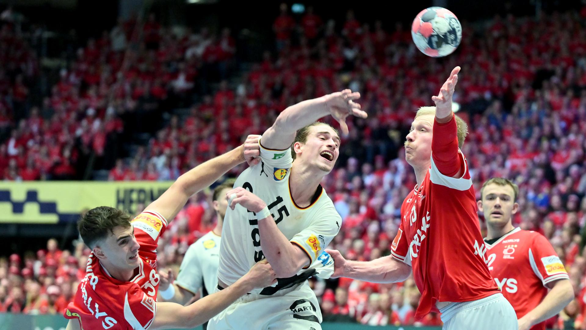 Das Bild zeigt ein Gerangel bei einem Handball-Spiel während eines Tor-Wurfs.