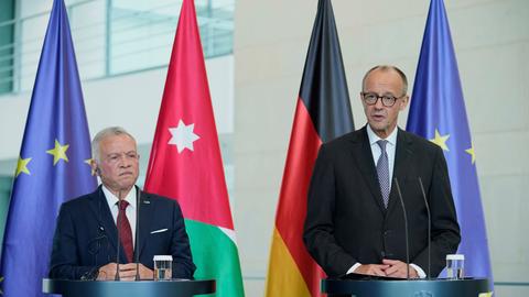 Der jordanische König Abdullah II.und Bundeskanzler Friedrich Merz stehen an Rednerpulten in Berlin. 