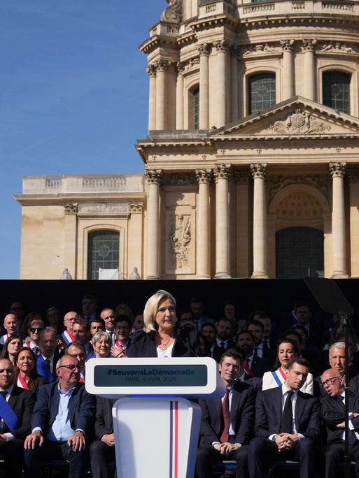 Marine Le Pen ist eine französische Politikerin der rechtspopulistischen bis rechtsextremen Partei Rassemblement National (RN), deren Vorsitz sie bis 2022 hatte. Sie spricht vor dem Invalidendom in Paris bei einer Demo gegen ihre Verurteilung.