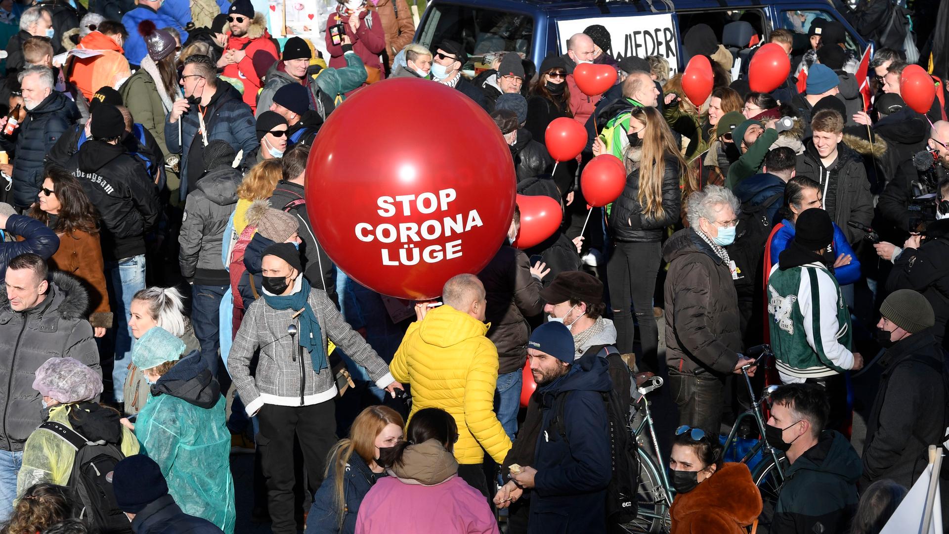 Teilnehmer einer Demonstration gegen die Coronama-Maßnahmen der Bundes- und Landesregierung halten einen Luftballon mit der aufschrift "Stop Corona-Lüge". Teilnehmer einer Demonstration gegen die Coronama-Maßnahmen der Bundes- und Landesregierung halten einen Luftballon mit der aufschrift "Stop Corona-Lüge".