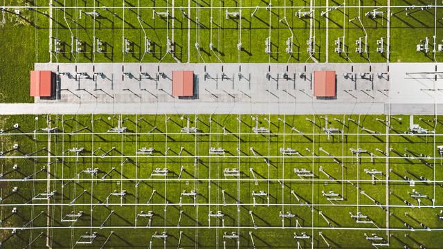 Luftbild auf ein Umspannwerk. Die Spannungsleitungen durchziehen die Wiese mit einem rasterartigen Muster.