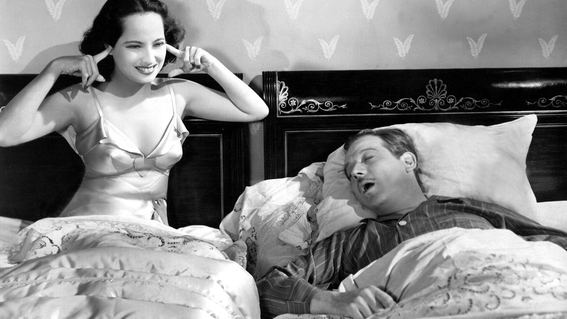 Merle Oberon und Melvyn Douglas, im Film THAT UNCERTAIN FEELING, 1941. Er schnarcht und sie hält sich die Ohren zu.