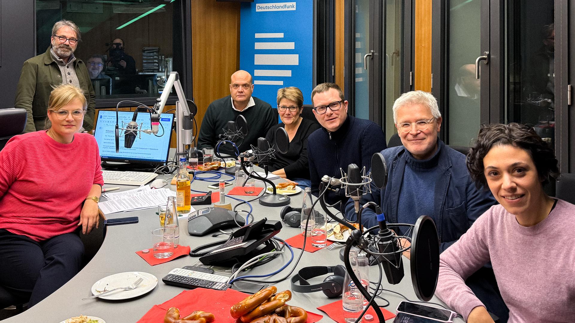 Nadine Lindner, Stephan Detjen (Deutschlandfunk), Robin Alexander (WELT), Sabine am Orde (taz), Ulf Buermeyer (Lage der Nation), Peter Dausend (ZEIT) und Katharina Hamberger (Deutschlandfunk) sitzen an einem Studiotisch unseres Hauptstadtstudios.