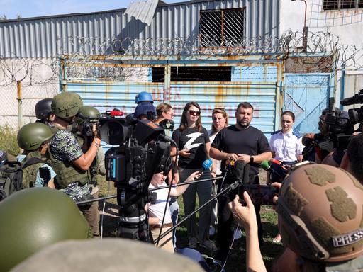 Denis Pushilin, the leader of the Donetsk People's Republic, background second right, speaks to foreign journalists at the destroyed barrack by following a strike on a prison housing POWs in Olenivka during a trip organized by the Russian Ministry of Defense, on the territory which is under the Government of the Donetsk People's Republic control, eastern Ukraine, Wednesday, Aug. 10, 2022. Russia has claimed that Ukraine's military used U.S.-supplied rocket launchers to strike the prison in Olenivka, a settlement controlled by the Moscow-backed Donetsk People's Republic. The Ukrainian military denied making any rocket or artillery strikes in Olenivka. (AP Photo)