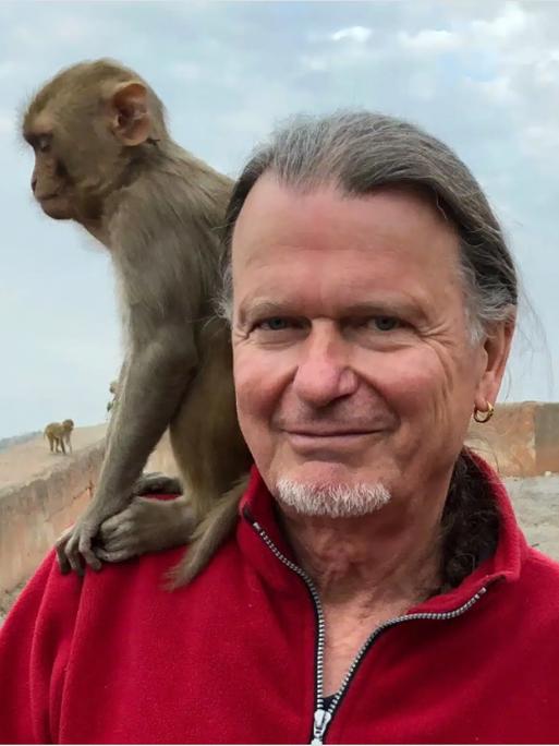 Porträt des Anthropologen und Primatenforschers Prof. Volker Sommer, ein kleiner Affe sitzt auf seiner Schulter