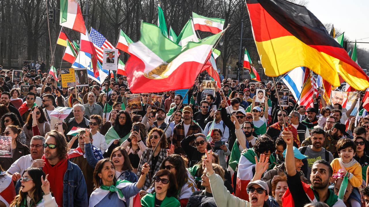 Das Foto zeigt eine Menschenmenge, die iranische, deutsche, US-amerikanische und israelische Flaggen schwenkt und gegen das iranische Regime protestiert. Die Demonstration fand am 7. März 2026 in Berlin statt.