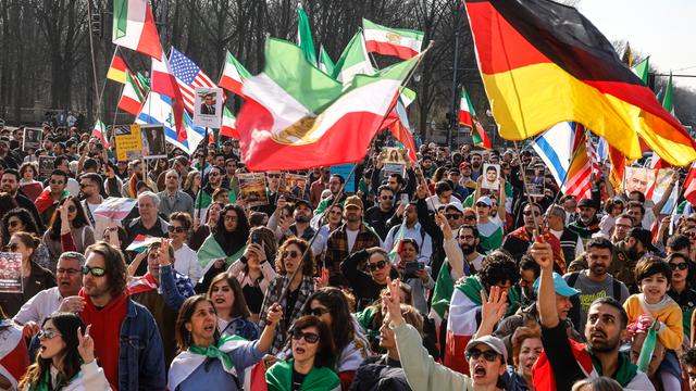 Das Foto zeigt eine Menschenmenge, die iranische, deutsche, US-amerikanische und israelische Flaggen schwenkt und gegen das iranische Regime protestiert. Die Demonstration fand am 7. März 2026 in Berlin statt.