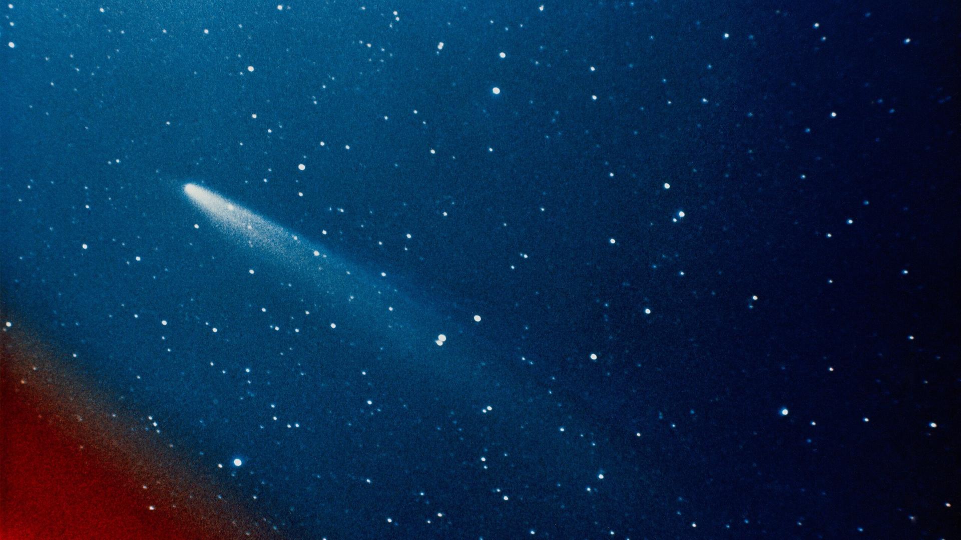Ein Komet am blauen Sternenhimmel.