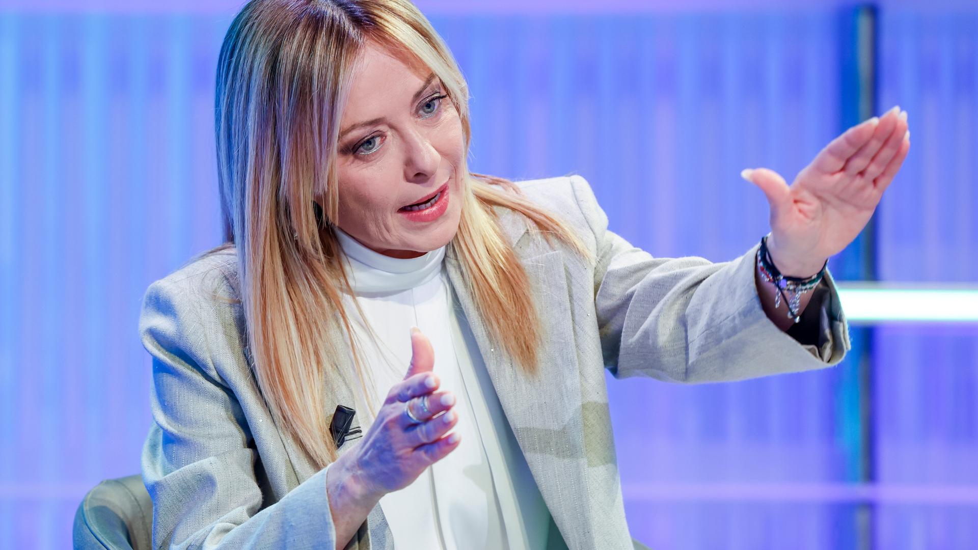 Giorgia Meloni sitzt in einem TV-Studio und gestikuliert während des Sprechens Giorgia Meloni sitzt in einem TV-Studio und gestikuliert während des Sprechens