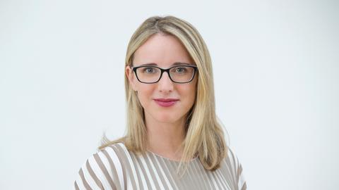 Porträtfoto von Alena Buyx. Die Vorsitzende des Deutschen Ethikrats hat schulterlange blonde Haare, trägt eine schwarze Brille und ein weiß-beige gestreiftes Oberteil. Sie blickt freundlich in die Kamera.