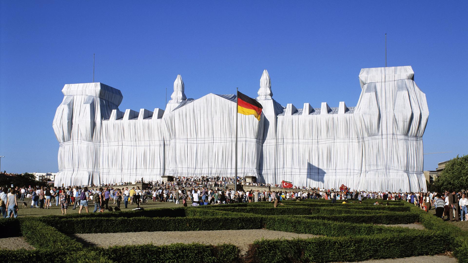 Der Reichstag in Berlin, verhüllt von Christo und Jeanne-Claude im Jahr 1995. Das Gebäude ist in weiße Tücher gehüllt.