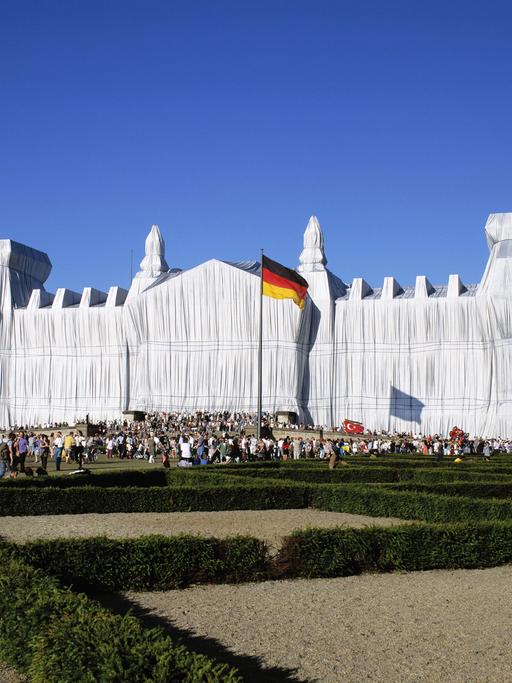 Der Reichstag in Berlin, verhüllt von Christo und Jeanne-Claude im Jahr 1995. Das Gebäude ist in weiße Tücher gehüllt.