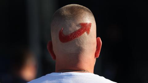 Ein AfD-Anhänger trägt ein Logo der Partei auf dem Hinterkopf.