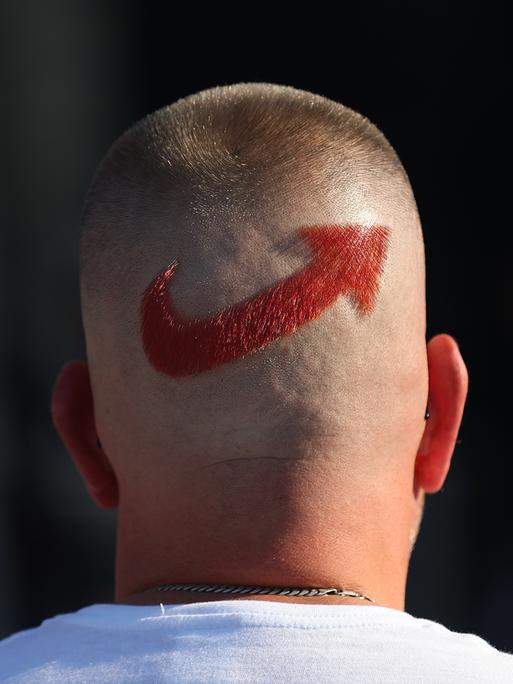 Ein AfD-Anhänger trägt ein frisierten Logo der Partei auf dem Hinterkopf.