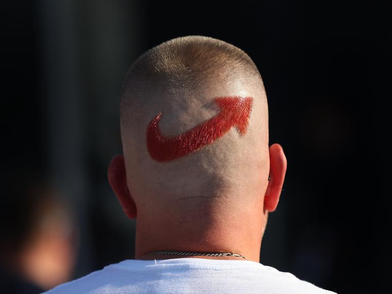 Ein AfD-Anhänger trägt ein frisierten Logo der Partei auf dem Hinterkopf.