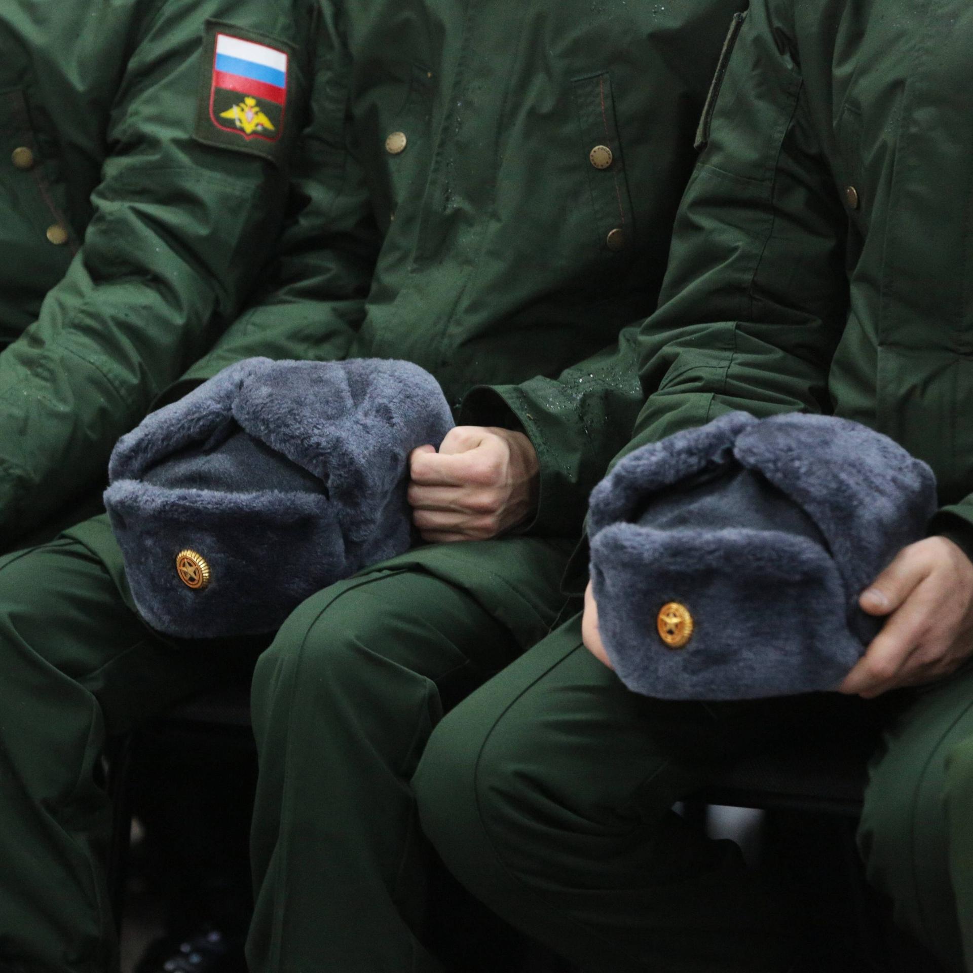 Zu sehen sind Mützen und Uniformen russischer Soldaten.