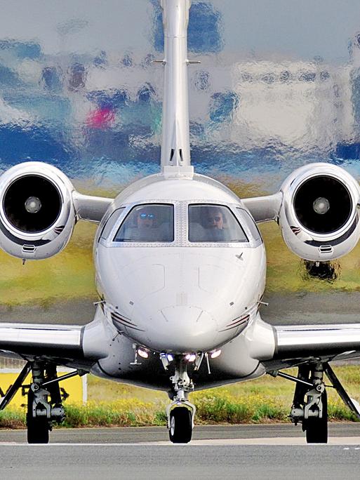 Ein Privatjet steht auf Frankfurter Flughafen auf dem Rollfeld bereit zum Abflug, der Blick richtet sich frontal auf das Flugzeug. Ein Privatjet steht auf Frankfurter Flughafen auf dem Rollfeld bereit zum Abflug, der Blick richtet sich frontal auf das Flugzeug.