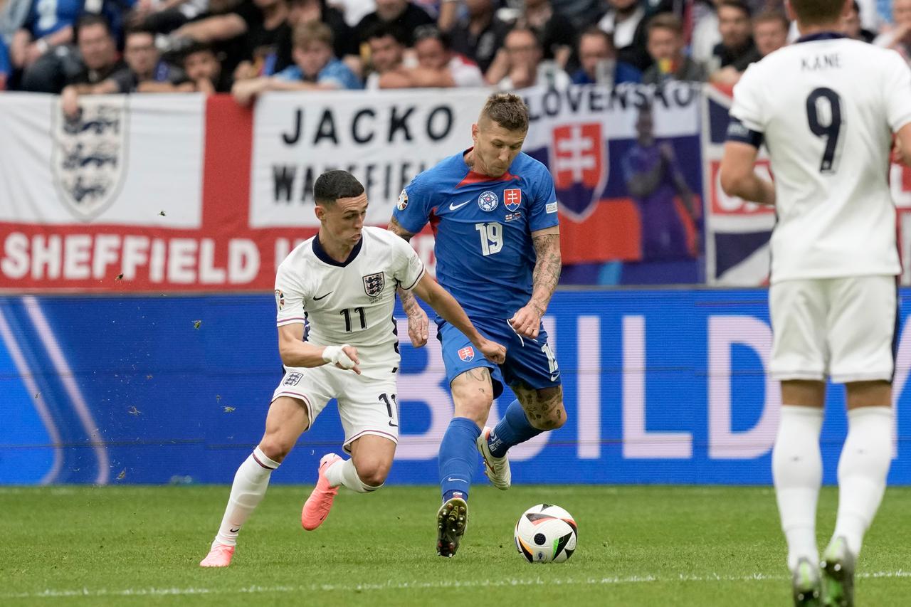 Englands Phil Foden (li.) kämpft mit dem Slowaken Juraj Kucka um den Ball während des Achtelfinalspiels zwischen England und der Slowakei bei der Fußball-Europameisterschaft 2024 in Gelsenkirchen.