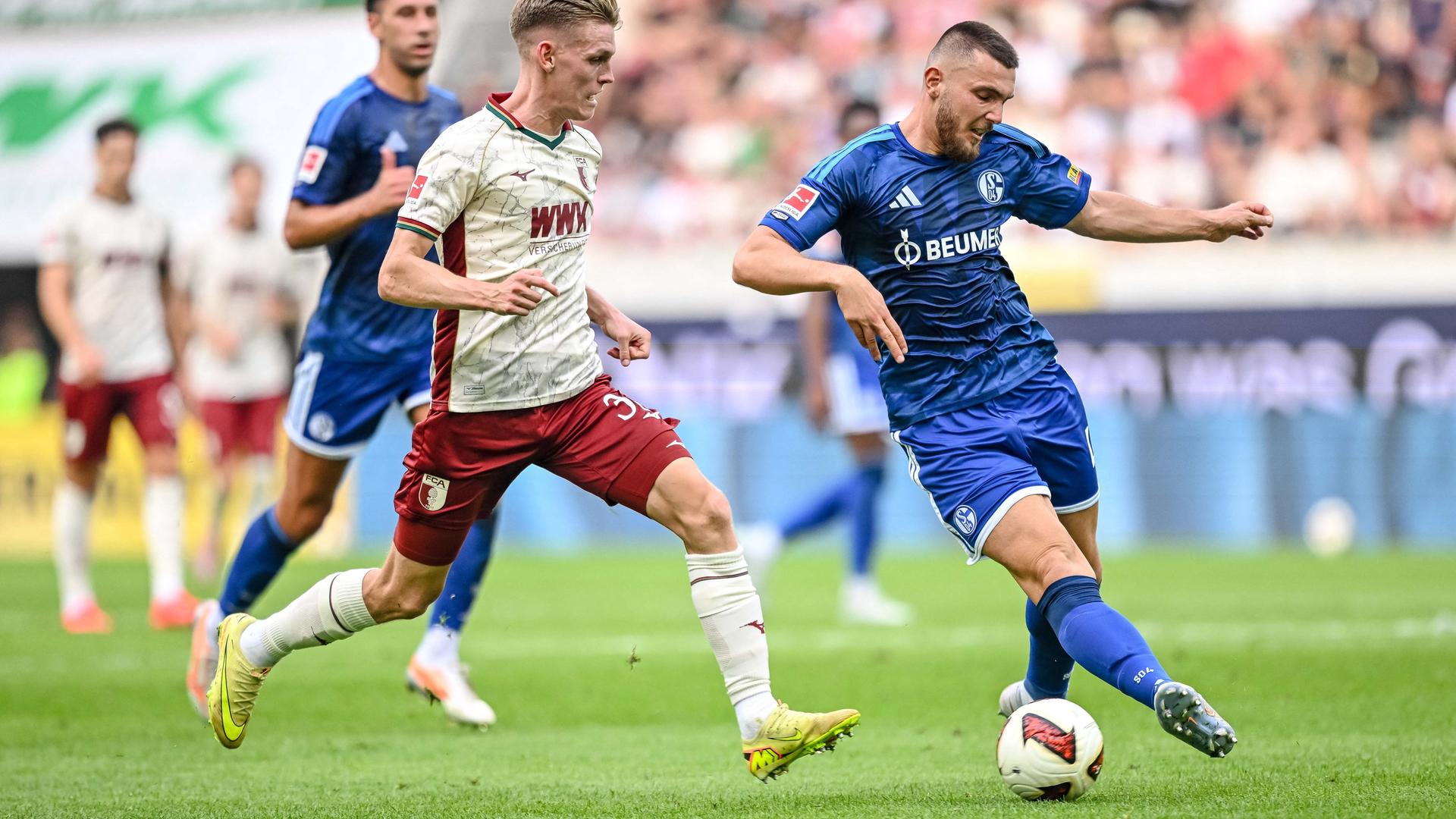 Zwei Fußballspieler kämpfen um den Ball.