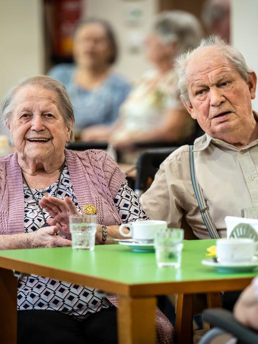 Rund vierzig Bewohner und Bewohnenrinnen des AWO-Seniorenzentrums an der Karl-Jarres-Strasse in Duisburg hoeren gemeinsam Schlager aus den 50ern bis 70ern, die von der Tanzband The Charlys des Karnevalsvereins Rote Funken gesungen werden. 