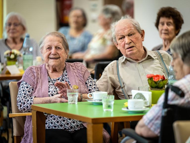 Rund vierzig Bewohner und Bewohnenrinnen des AWO-Seniorenzentrums an der Karl-Jarres-Strasse in Duisburg hoeren gemeinsam Schlager aus den 50ern bis 70ern, die von der Tanzband The Charlys des Karnevalsvereins Rote Funken gesungen werden. 