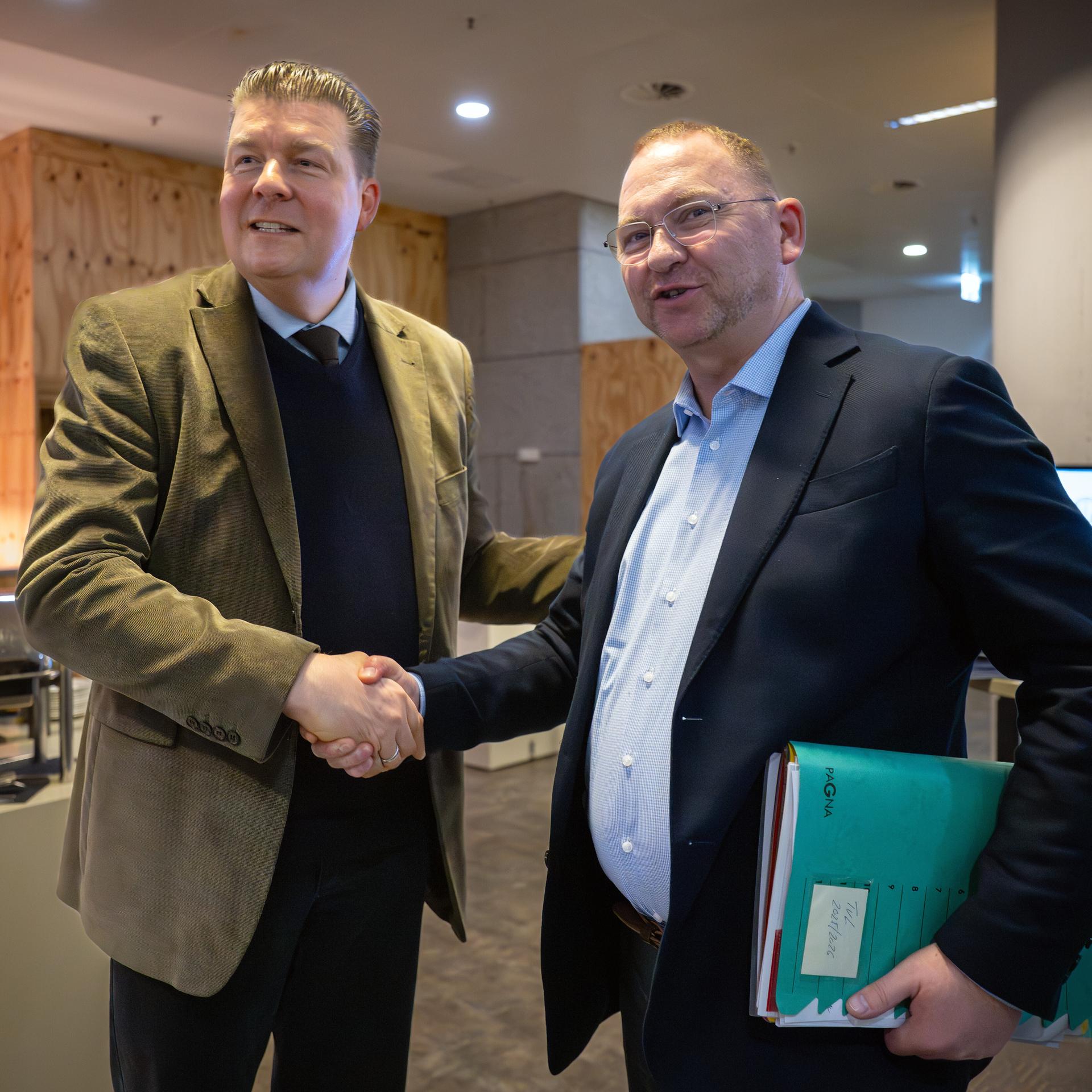 Der Hamburger Finanzsenator und Verhandlungsführer der Länder, Dressel, und Verdi-Chef Werneke geben sich die Hand.