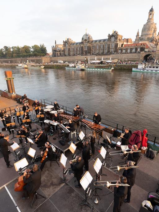 Musiker der Dresdner Sinfoniker stehen während des Konzerts «Elbkarawane» auf einem Schubverband vor der Kulisse der Dresdner Altstadt mit der Frauenkirche. Musiker der Dresdner Sinfoniker stehen während des Konzerts «Elbkarawane» auf einem Schubverband vor der Kulisse der Dresdner Altstadt mit der Frauenkirche.