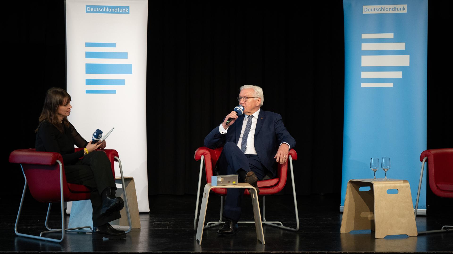 Bundespräsident Frank-Walter Steinmeier sitzt bei seinem Besuch in der Kulturfabrik Hoyerswerda bei einem Bühnengespräch auf seinem Platz. 