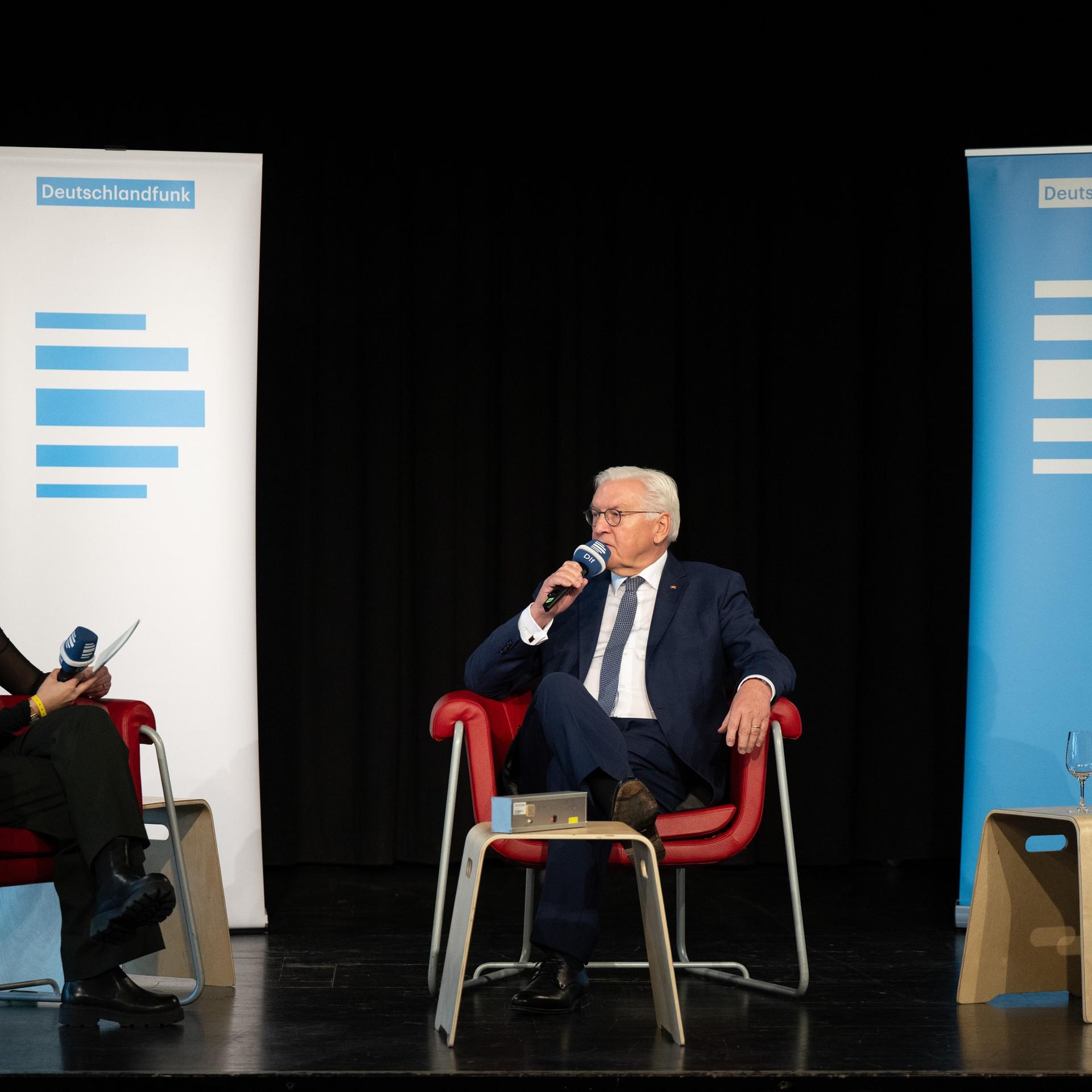 Bundespräsident Frank-Walter Steinmeier sitzt bei seinem Besuch in der Kulturfabrik Hoyerswerda bei einem Bühnengespräch auf seinem Platz. 
