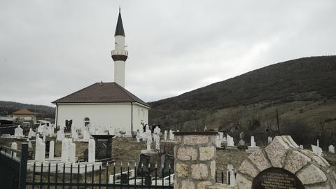 Die weiße Askerli Moschee liegt inmitten eines muslimischen Friedhofs. Vorne ist ein Zaun.  